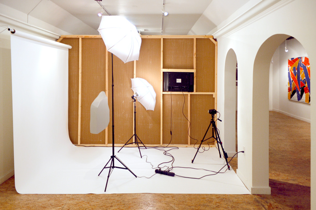 Art installation: white backdrop and cameras set up like a photoshoot