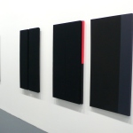 A series of painting of either plain black canvas or black and another color
